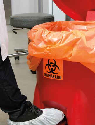 red biohazard waste bag and container with a biohazard safety label on it